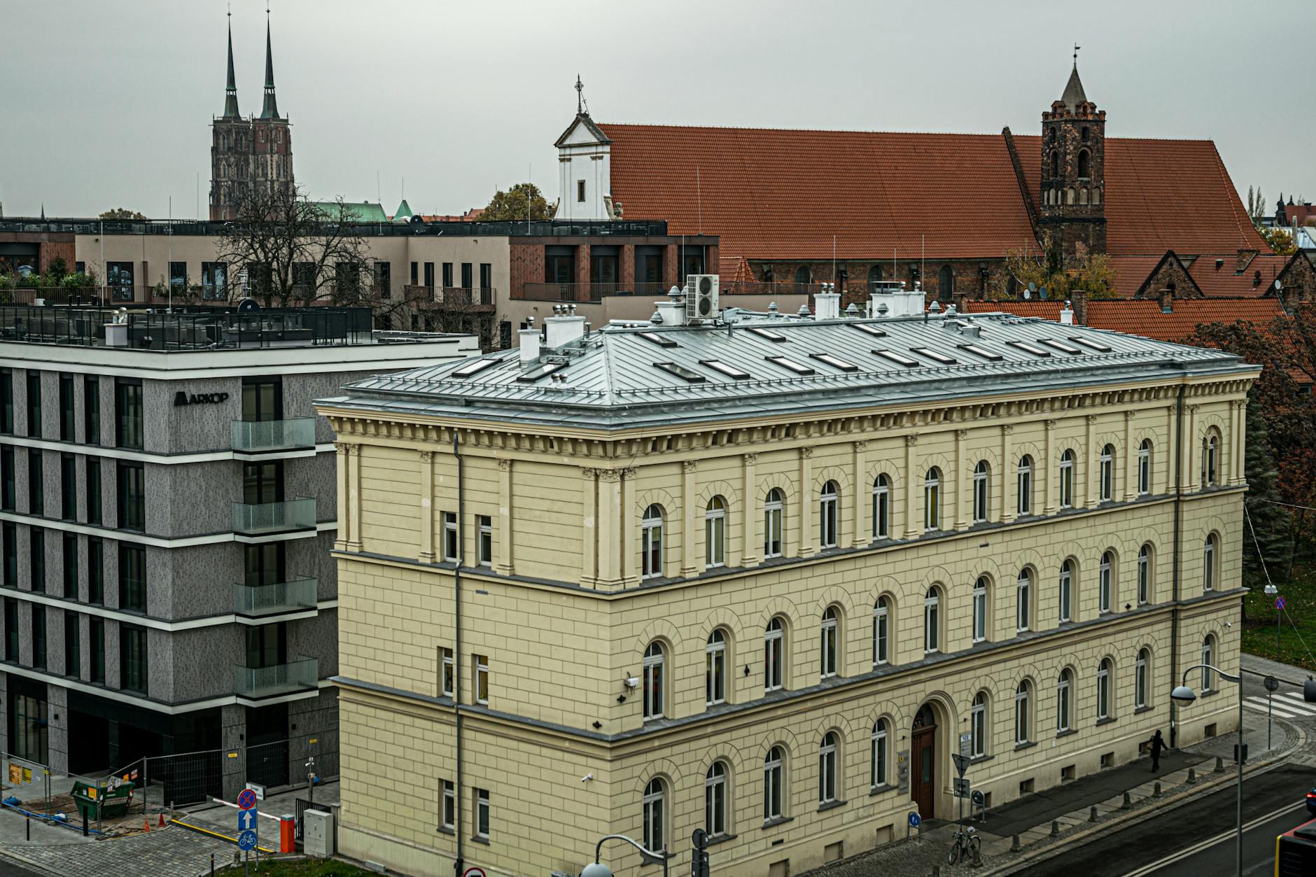 Herb Częstochowy na tle nowoczesnego budynku, symbolizujący inwestycje i rozwój miasta.